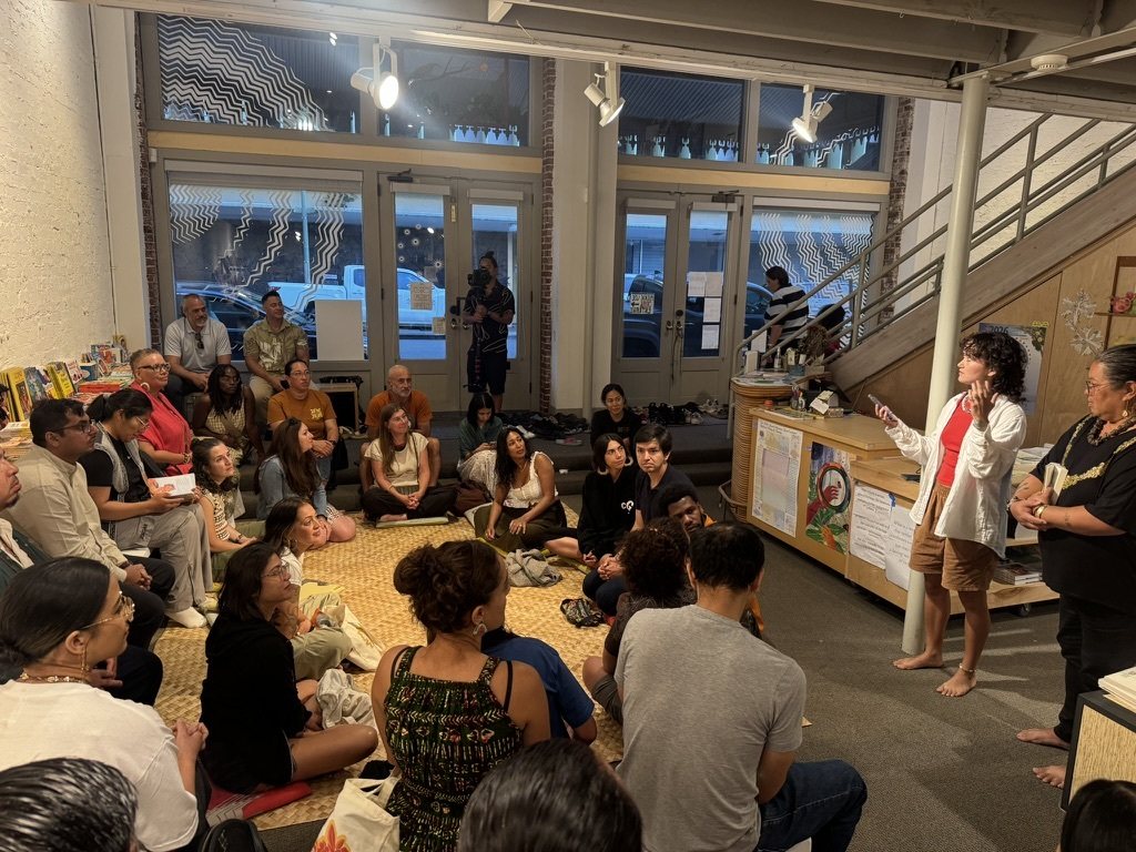 Cohort members seated on the floor listening to a speaker